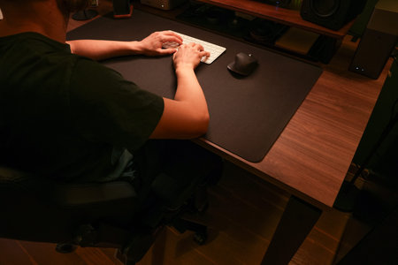 Man working on keyboard at modern desk