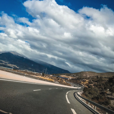 highway in the mountains with blue sky and white clouds, Spainの写真素材