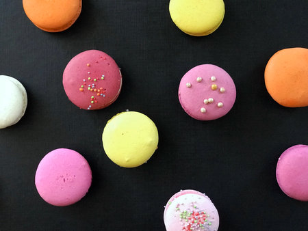 Colorful macaroons on a black background, top view.の写真素材