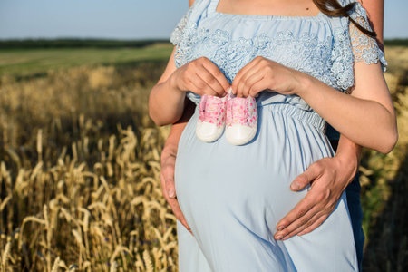 young pregnant couple in the field. beautiful mature couple relaxing in the summer nature meadowの写真素材