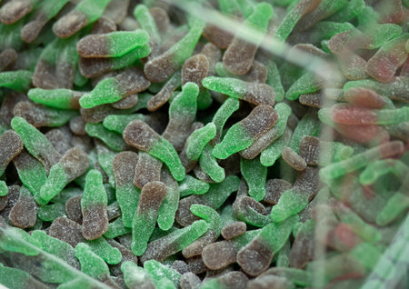 closeup of green, gray candy, healthy jelly sweets in plastic boxes on market stand in...