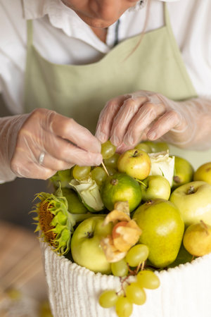 Hobby and activity:florist makes edible fruits arrangement gift on wooden table. Do it yourself veggie:how to make handmade edible bouquet: steps, tutorial. Healthy deliciousの写真素材