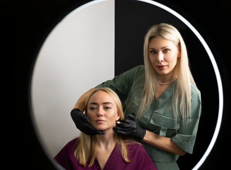 Two beauticians, cosmetologists on white black background. Blond hair professionals wear medical...