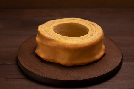 Lithuanian, Polish, German spit cake sakotis, baumkuchen, sekacz on wooden table. Delicious homemade traditional cake. Low key photo, horizontal plane.の写真素材