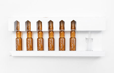 Isolated set of Eucapil fluridil lotion in ampules in paper box,cosmetic product for topical use in androgenetic alopecia,hair loss on blue background.Flatly,horizontal, Bialystok, Poland: 23.02.2023のeditorial素材