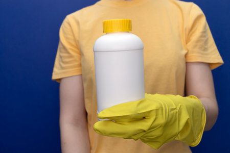 Woman In Yellow Gloves Holds White Bottle With Pipe Cleaner Granules. Removal Of Blockage In Sink,...