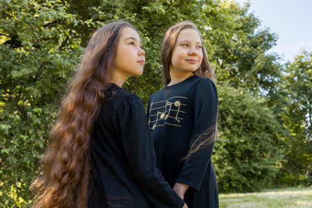 Two Little Girls, Sisters With Extra Long Curly Shiny Hair Hold Hands In Park, Nature On Background....