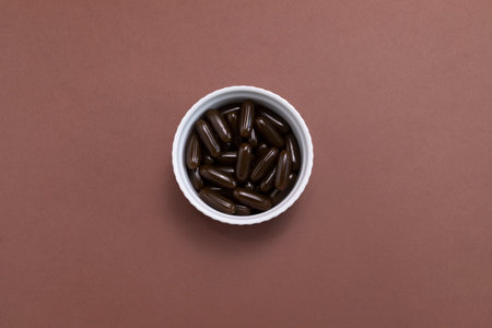 Flatly Sunflower Lecithin Brown Softgel Pill Capsule In White Bowl On Brown Background. Top View Vitamin, Dietary Supplements. Lecithin Benefits For Skin, Digestion, Lower Cholesterol. Horizontal.の写真素材