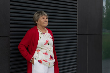 Closeup Real Senior Old 70s Woman, Dark Wall on Background. Portrait Of Kind Relaxed Elderly Female Outdoor, Copy Space For Text. Authentic Lifestyle Horizontal Planeの写真素材