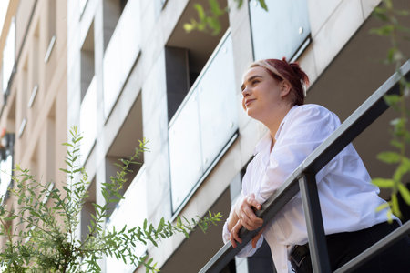 Bottom View Against Background Of High-rise Building With Trees Young Business Woman 20s Looking...