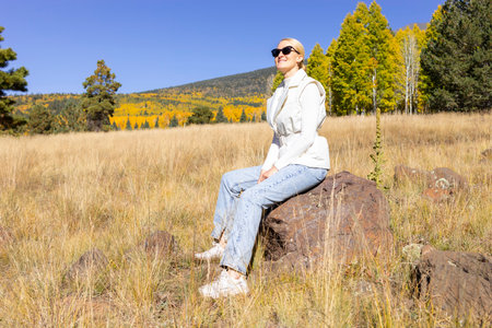 Happy Smiling Woman Takes A Rest During Hiking In Mountains At Fall Season On Bright Sunny Day....