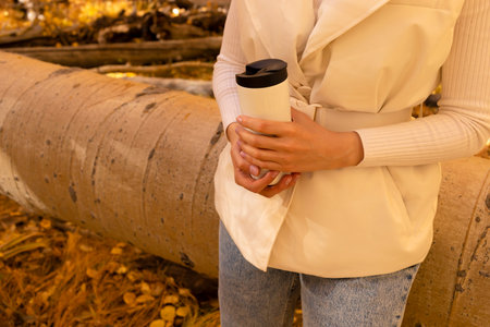 Caucasian Female Drinks Autumn Beverage From flask, Travel Mug Outside In Park Or Forest, Wears Warm...