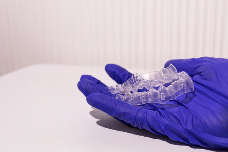 Closeup Invisible Orthodontics Cosmetic Aligners In Doctors Hand. Adjusting Transparent, Invisalign...