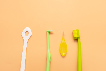 Personal Dental Oral Hygiene Set Kit. Tongue Scraper, Toothbrush, Interdental Toothbrush For Cleaning Between Teeth On Peach Yellow Background. Space For Text. Horizontal Planeの写真素材