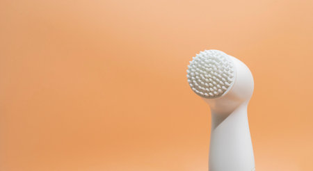 Design Electrical Deep Cleansing Face Brush On Peach Orange Background. Copy Space For Text. Deep Cleansing Facial Remove Makeup. Skin Care Technology. Horizontal Bannerの写真素材