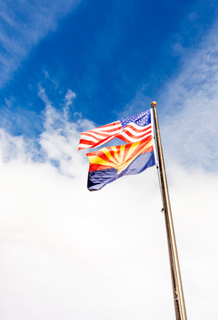 Design Waving American USA Flags and Flag of Arizona State on Flagpole On Background Of Blue White Sky, Template Vertical Plane, Copy Space.の写真素材