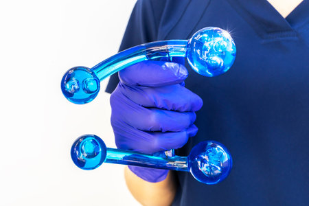 Doctor Holds Blue Acrylic Back, Leg, Neck Massage Tool with Gloved Hand. Deep Tissue Massage, Thumb...