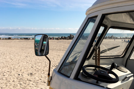 Window With Mirror Of Orange Camper Van Parked In The Seashore, Yellow Sand And Water, Ocean Line On Background, Travel Destination, Summer And Vacation. Horizontal.の写真素材