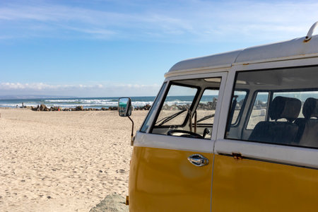 Camper Trailer, Van Parked In The Seashore, Yellow Sand And Water, Ocean Line On Background, Nobody. Travel Destination, Summer And Vacation. Horizontal.の写真素材