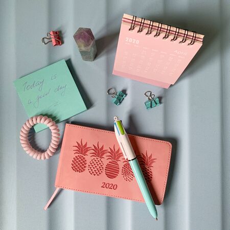 Flat layout of blank notepad with pen and stickers on colorful background