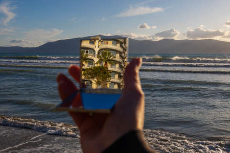 cropped view of mirror with reflection of palm tree and buildingの写真素材
