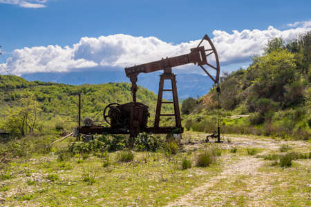 Silhouetted pumpjack in the oil fieldの写真素材