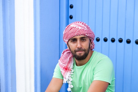 Young smiling handsome arabic man wearing traditional clothes