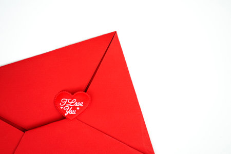 Red paper envelope with blank white note mockup inside and hearts on white background. Flat lay, top view. Romantic love letter for valentine day conceptの写真素材