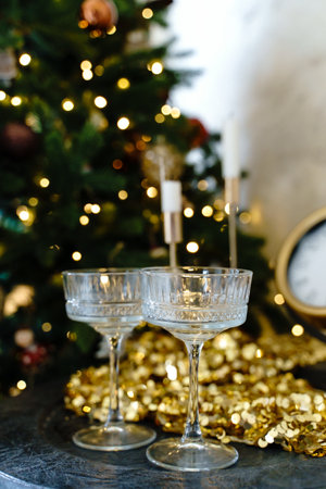 Two glasses of champagne on a table near the Christmas treeの写真素材