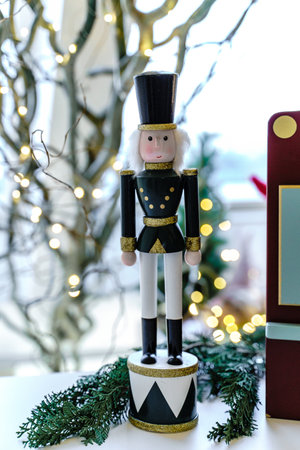 Decorative statue in the form of a tin soldier on a table near spruce branches, which stands on a...
