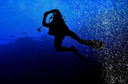 Silhouette of a diver in blue seaの写真素材