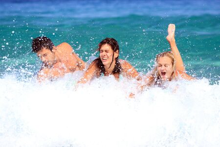 Portrait of joyful group of people having fun in the sea and laughing
