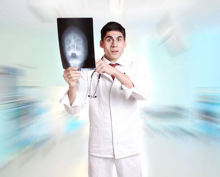 Caucasian mid adult male doctor holding up xrays.の写真素材