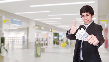 Portrait of a salesman in the shopping mall holding dollars in his hand

の写真素材