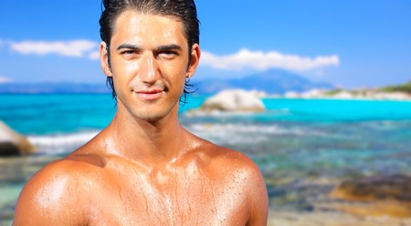 sexy caucasian fit man posing in a beach の写真素材