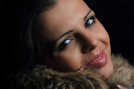 Portrait of a beautiful young woman over dark backgroundの写真素材