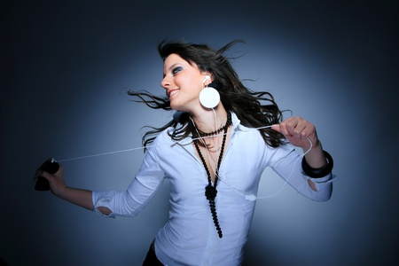 Beautiful Girl listening music with her cell phone over blue background の写真素材