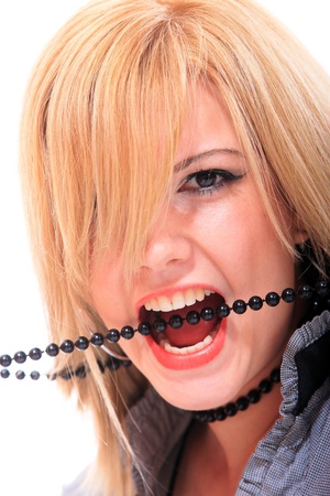 Woman open mouth and teeth biting on faux pearlsの写真素材