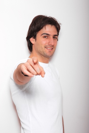 portrait of a young man blue jeans and white tshirt  over light wallの写真素材