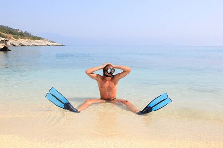 Diver withTube and mask for a scuba diving on seacoast with sandの写真素材