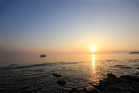 Sunrise over the Ionian sea with fishing boat on Zakynthos island Greeceの写真素材