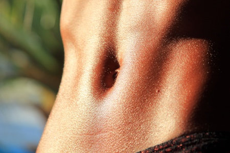 Sexy and fit belly on young woman against the sunの写真素材