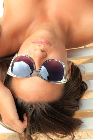 Pretty female with sunglasses on at the beachの写真素材