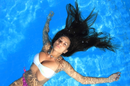 A beautiful woman relaxing in the poolの写真素材