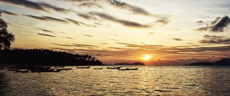 Beautiful sunrise in Rawai Phuket island Thailand with Long tailed boat Ruea Hang Yaoの写真素材
