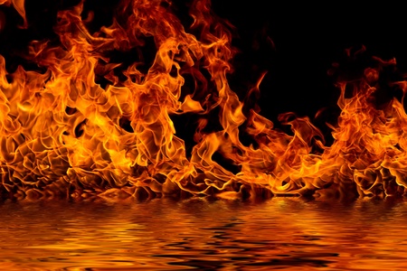 Blazing flames with water reflections over black backgroundの写真素材