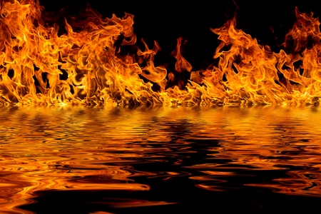 Blazing flames with water reflections over black backgroundの写真素材