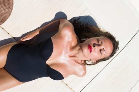 Young woman suntanning on her private yachtの写真素材