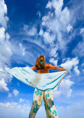 Woman with sarong pareo over sky backgroundの写真素材