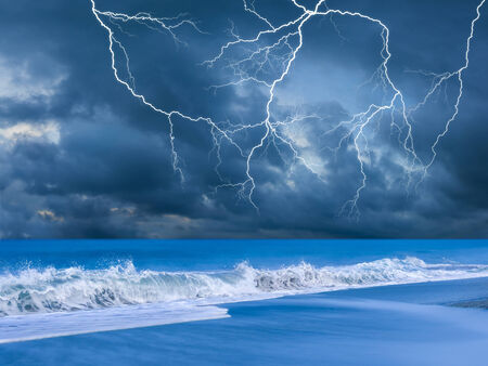 Beach on a stormy evening with lightningsの写真素材
